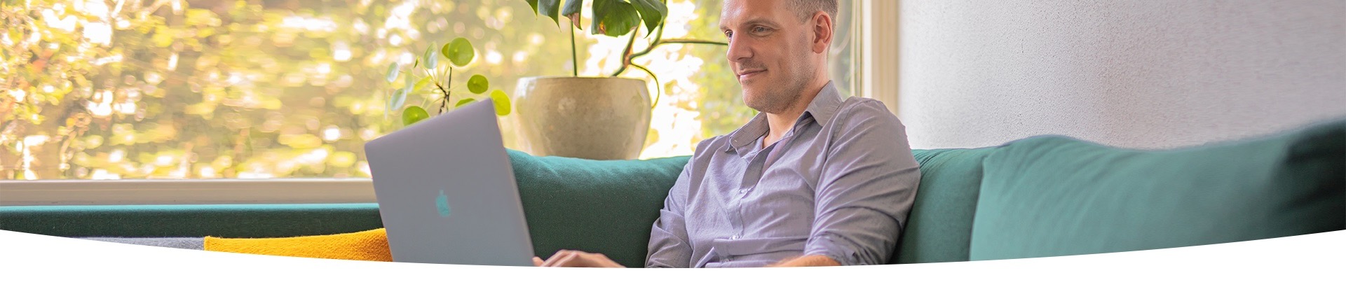 Man zit op een bank met een VGZ-factuur en een smartphone in zijn hand