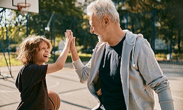 Jonge zoon en vader high five bij basketbal in vrije tijd